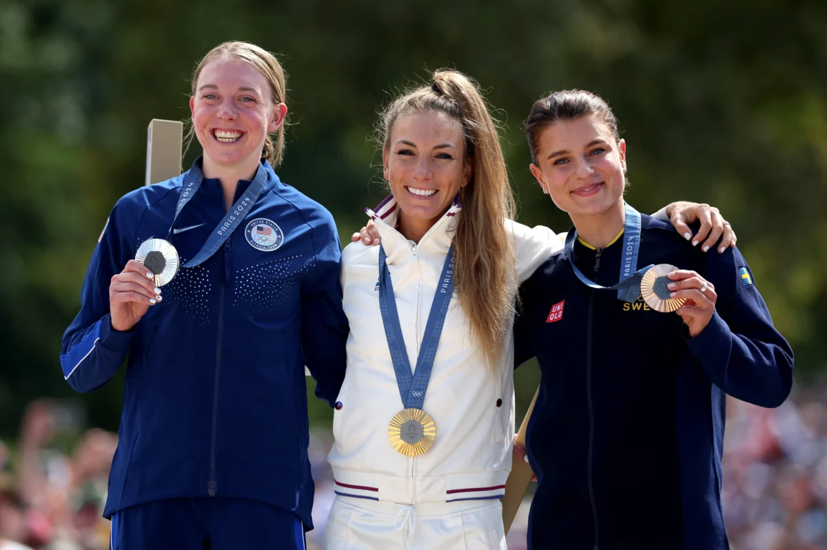 Gold medalist Pauline Ferrand Prevot of Team France (C), Silver medalist Haley Batten of Team USA (L) and Bronze medalist Jenny Rissveds of Team Sweden (R) pose on the podium during the Women’s Cross-Country Cycling Mountain Bike Gold Medal race during the Olympic Games at Elancourt Hill in France, on July 28, 2024. (Jared C. Tilton/Getty Images)
