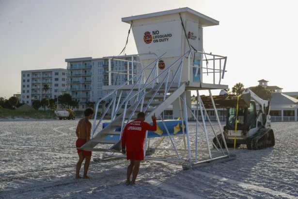 Matthew Blowers and Patrick Brafford prepare to secure a lifeguard tower in preparation of potential storm at Clearwater Beach