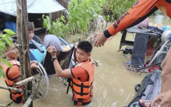 Rescuers carry a resident trapped in their homes after floods caused by Tropical Storm Trami, locally named Kristine, hit their village at Libon, Albay Province, Philippines, on Oct. 23, 2024. (Philippine Coast Guard via AP)