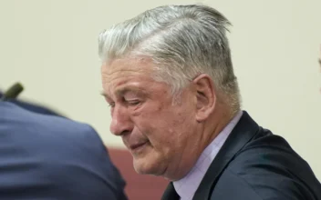 Actor Alec Baldwin, center, reacts as he sits between his attorneys Alex Spiro, left, and Luke Nikas after the judge threw out the involuntary manslaughter case for the 2021 fatal shooting of cinematographer Halyna Hutchins during filming of the Western movie "Rust," Friday, July 12, 2024, in Santa Fe, N.M.   (Ramsay de Give/Pool Photo via AP)