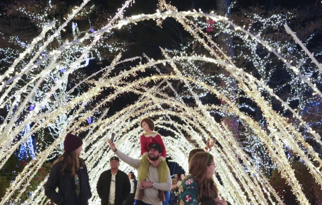 A family walks through a light display at the Lights of Joy display in Kennesaw, Ga., on Dec. 16, 2024. (Brynn Anderson/AP Photo)