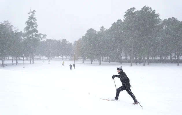 A person uses cross-country skis as he walks through a snow covered hill at Herman Park in Houston on Jan. 21, 2025. (Ashley Landis/AP Photo)