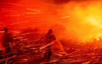 Firefighter Joshua Cari sprays water while battling the Lilac Fire near the Bonsall community of San Diego County, Calif., on Jan. 21, 2025. (Noah Berger/AP Photo)