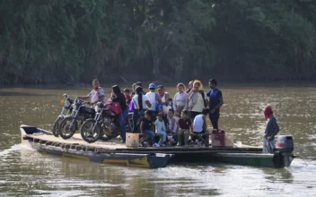 Residents cross a river to Venezuela from Colombia's Tibu on Jan. 21, 2025. (Fernando Vergara/AP Photo)
