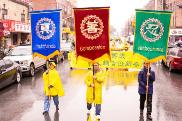 Chen Shanfeng (R) is holding the banner of “Forbearance” in Falun Gong parade on Eighth Avenue in Brooklyn, New York on Feb. 16, 2025. (Larry Dye/The Epoch Times)