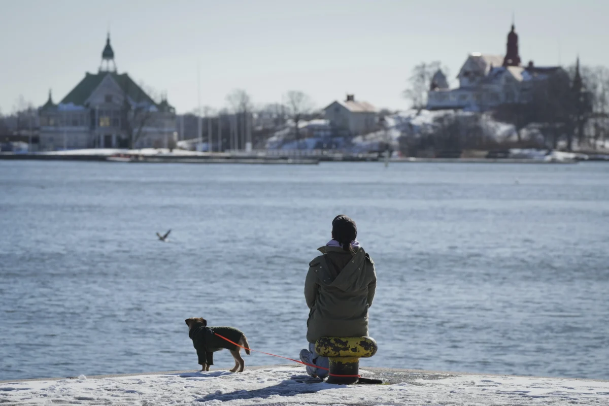 A woman enjoys a sunny and frosty day on the embankment of the South Harbour in Helsinki, Finland, on March 15, 2025. (Sergei Grits/AP Photo)