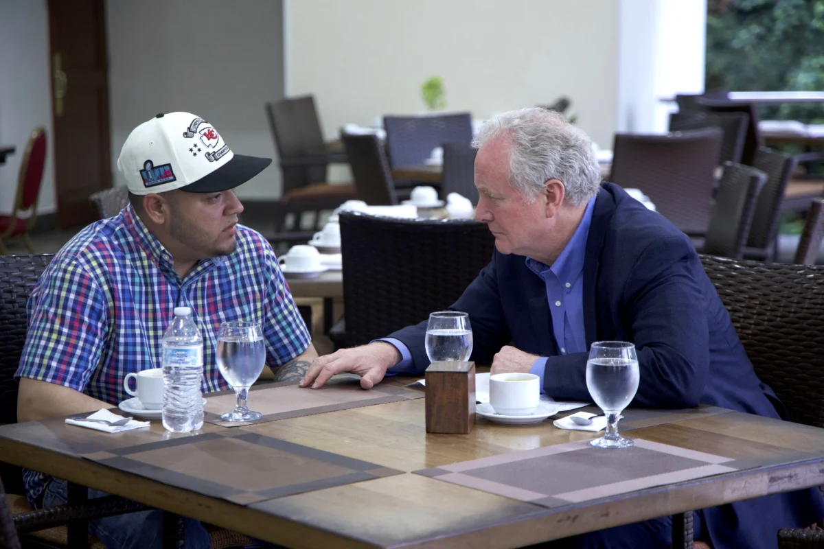 Sen. Chris Van Hollen (D-Md.) speaks with Kilmar Abrego Garcia (L) in a hotel restaurant in San Salvador, El Salvador, on April 17, 2025. (Press Office Senator Van Hollen via AP)
