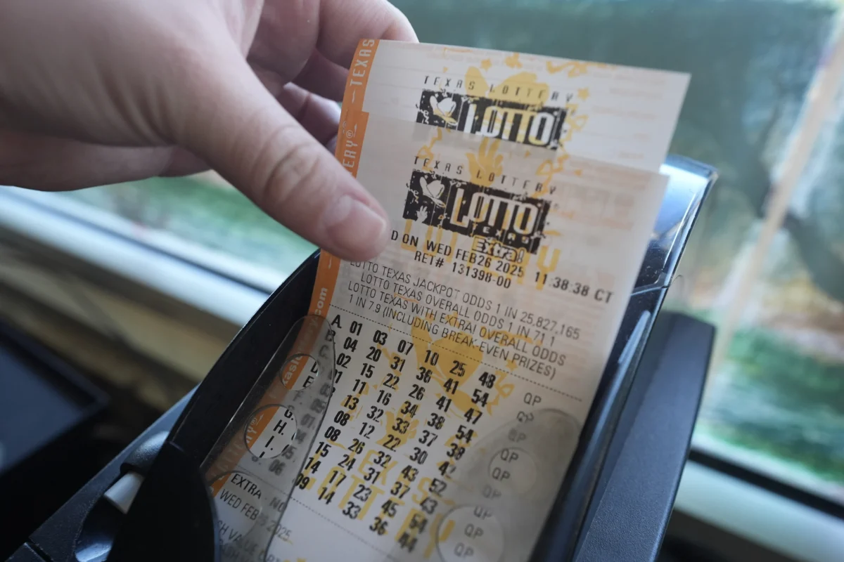 A man grabs printed tickets from a Texas Lottery sales terminal at Fuel City in Dallas, Texas, on Feb. 26, 2025. (LM Otero/AP Photo)