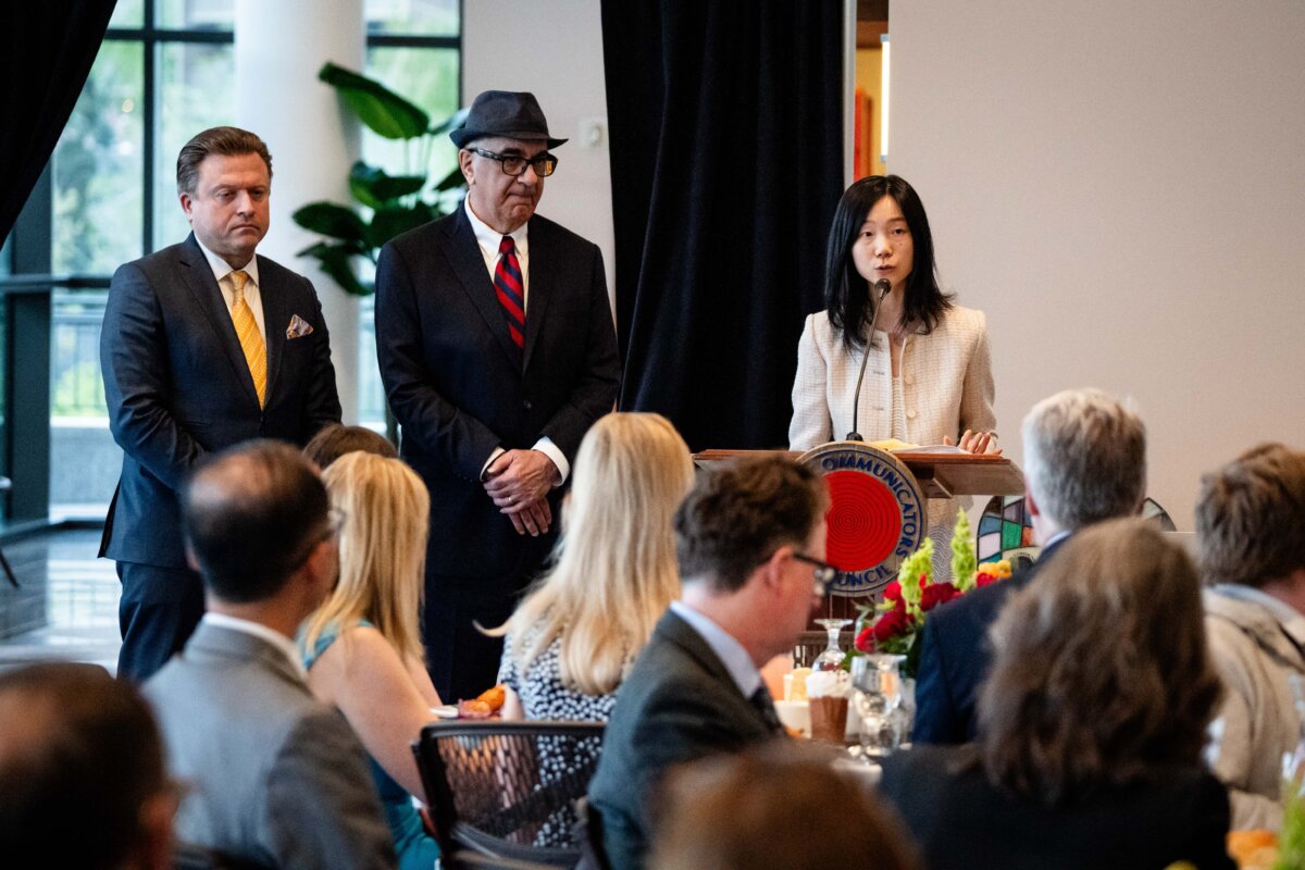 With Epoch Times senior editor Jan Jekielek (L) and reporter Dan Berger (2nd L) beside her, reporter Eva Fu accepts her 2025 Wilbur Award during a banquet at the Religion Communicators Council annual conference in Salt Lake City on April 25, 2025. (Madalina Vasiliu/The Epoch Times)