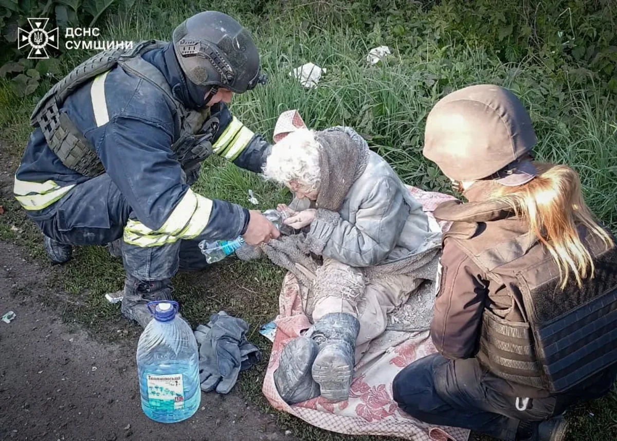 A rescue worker helps an injured woman evacuated from a building that was allegedly damaged by a Russian strike in the Sumy region, Ukraine, on May 8, 2025. (Ukrainian Emergency Service via AP)