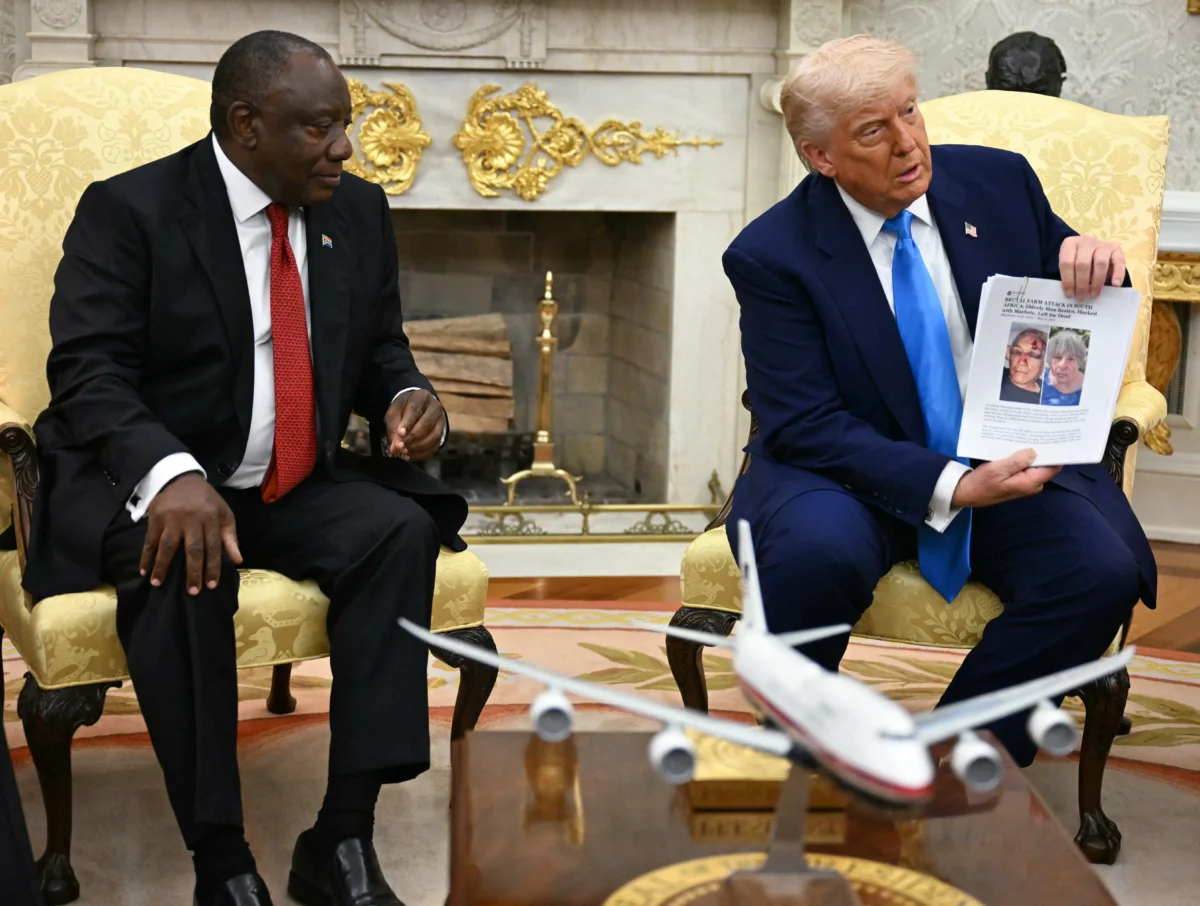 President Donald Trump holds up a picture as he meets with South African President Cyril Ramaphosa in the Oval Office, on May 21, 2025. (Jim Watson/AFP via Getty Images)