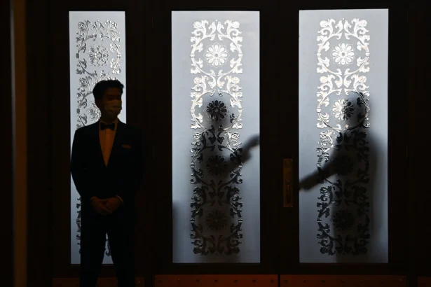 Security guards stand behind a glass door during the 14th National People's Congress (NPC) in Beijing on March 6, 2024. (Greg Baker/AFP via Getty Images)