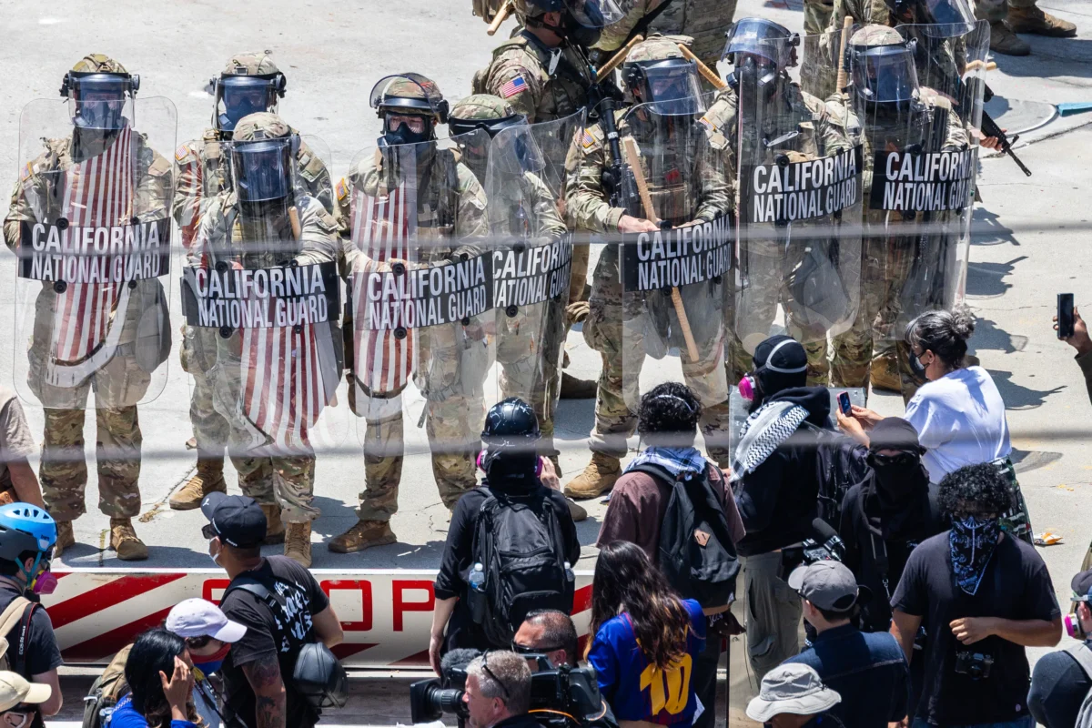 Protestors confront federal agents and California National Guardsmen in Los Angeles on June 8, 2025. (John Fredricks/The Epoch Times)