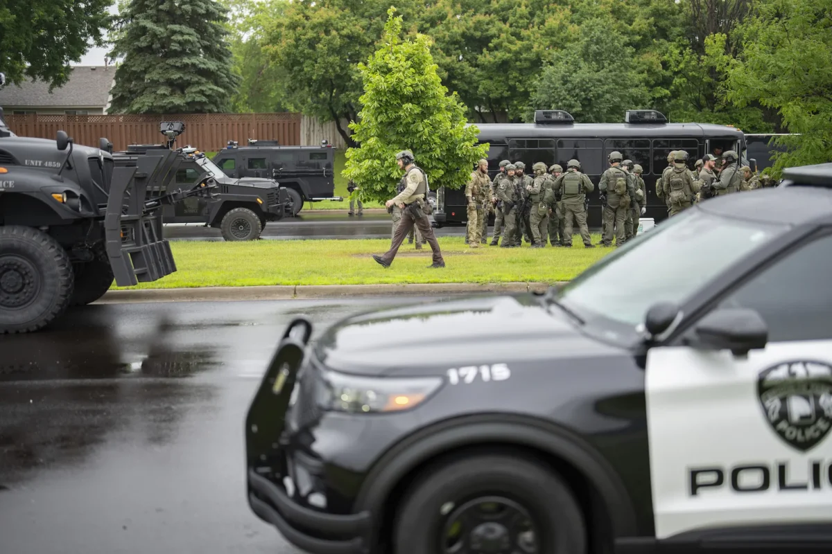 Law enforcement officers including local police, sheriffs, and the FBI, stage less than a mile from a shooting in Brooklyn Park, Minn., on June 14, 2025. (Alex Kormann/Star Tribune via AP)