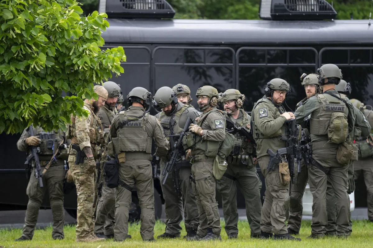 Law enforcement officers including local police, sheriffs, and the FBI, stage less than a mile from a shooting in Brooklyn Park, Minn., on June 14, 2025. (Alex Kormann/Star Tribune via AP)