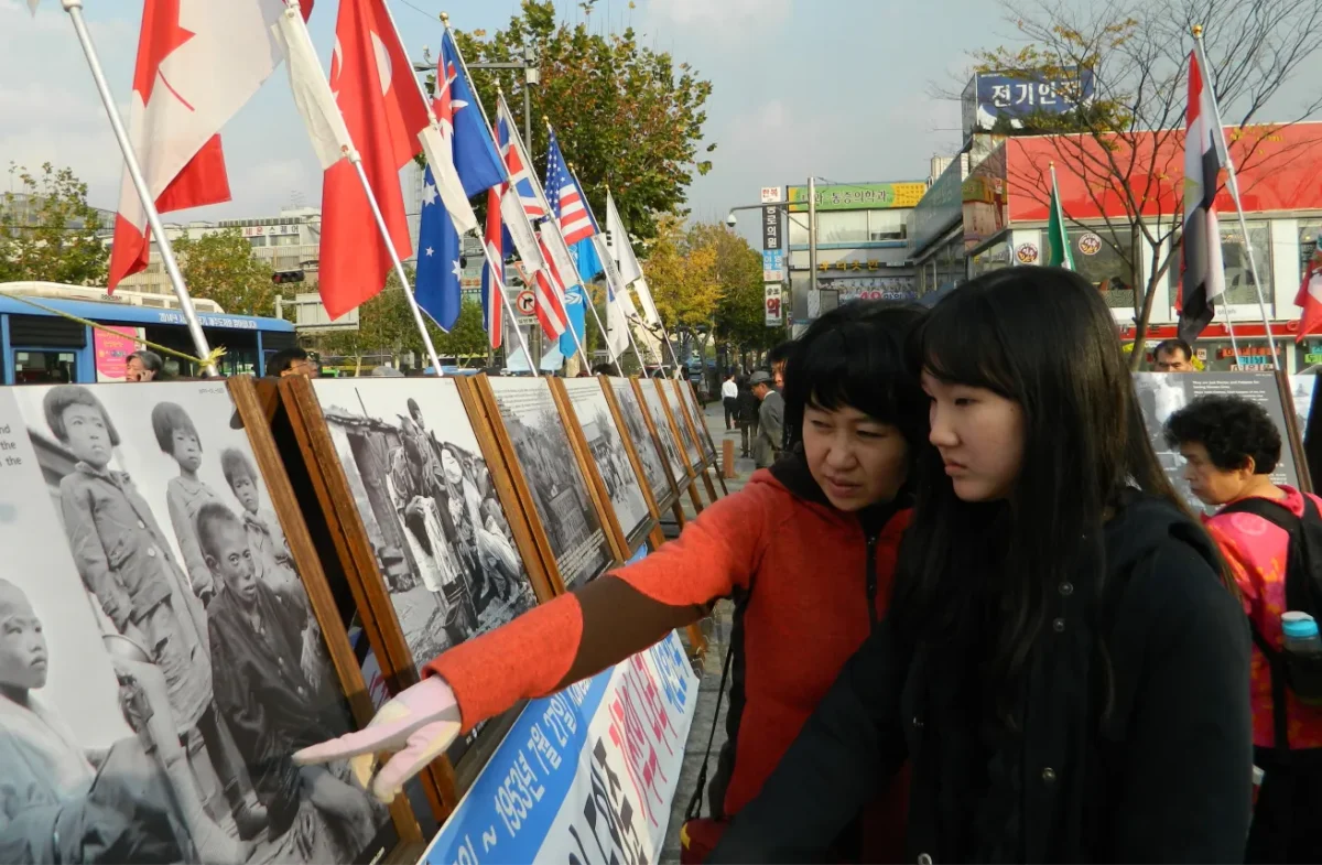 A mother brings her daughter to teach her about the horrors of the June 25, 1950, Korean War through photos in Nov. 12, 2011. (Courtesy of Ahn Jae-chul, president of The World Peace Freedom United)