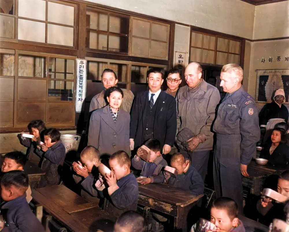 Officials from the United Nations Civil Assistance Command Korea (UNCACK) observe milk being distributed to children at Gongdeok Elementary School in Mapo-gu, Seoul, South Korea, on Feb. 12, 1953. (Courtesy of Ahn Jae-chul, president of The World Peace Freedom United)