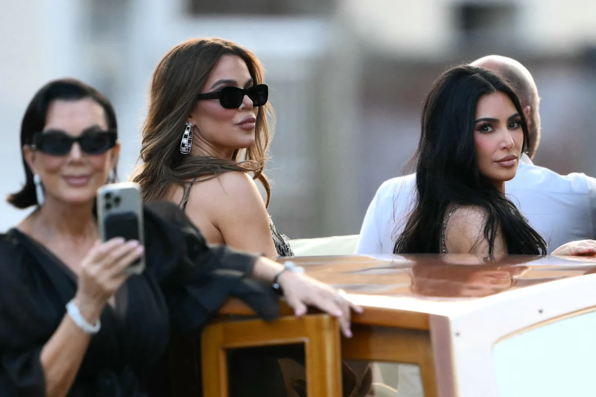 Television personality Kris Jenner (L), Khloe Kardashian (C) and reality TV personality Kim Kardashian stand on a taxi boat as they leave the Gritti Palace Hotel ahead of the wedding of Amazon's founder Jeff Bezos with Lauren Sanchez, in Venice, Italy, on June 26, 2025. (Marco Bertorello/AFP via Getty Images)
