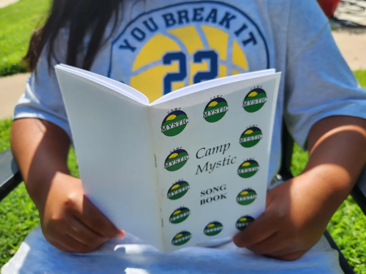 Julia looks at her Camp Mystic songbook in Oklahoma City as she recounts her experience in the Guadalupe River flood and aftermath on July 8, 2025. (Andrew Griffin/NTD)