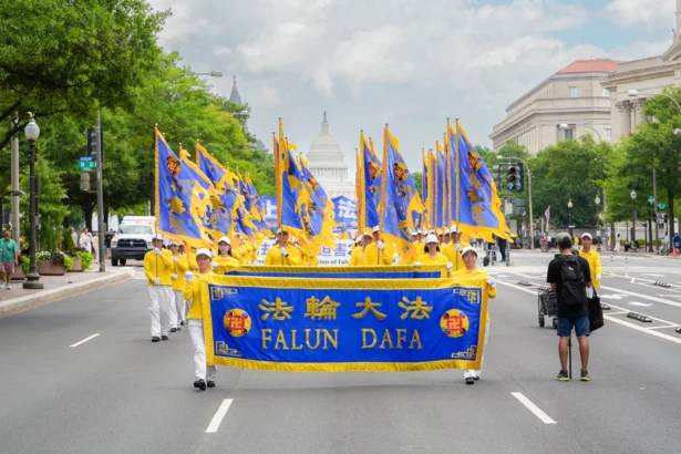Falun Dafa practitioners take part in a march calling for the end of the Chinese Communist Party’s 26 years of persecution of Falun Gong in China, in Washington on July 17, 2025. (Madalina Kilroy/The Epoch Times)