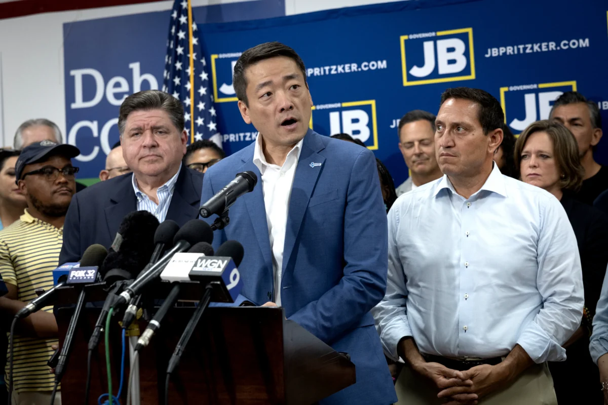 Illinois Gov. JB Pritzker (L) and Texas Rep. Trey Martinez Fischer (R) listen as Texas House Democratic Caucus Chair Gene Wu speaks to reporters during a press conference at the DuPage County Democratic Party headquarters in Carol Stream, Ill., on Aug. 3, 2025. (Scott Olson/Getty Images)