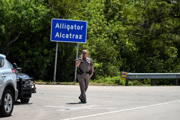 A Florida Highway Patrol officer looks on as protesters gather to demand the closure of the immigrant detention center known as 'Alligator Alcatraz' at the Dade-Collier Training and Transition Airport in Ochopee, Fla., on July 22, 2025. (Chandan Khanna/AFP via Getty Images)