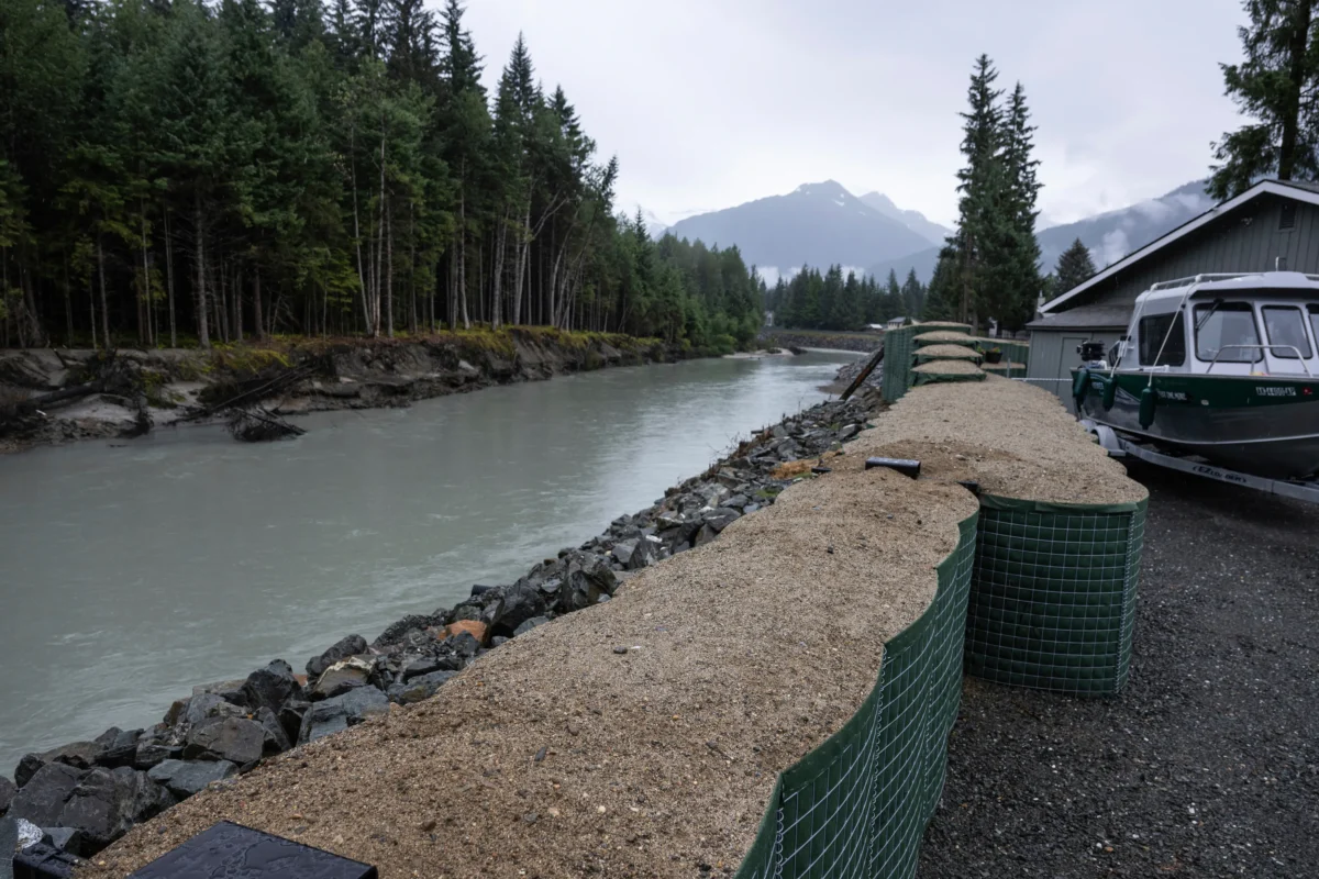 HESCO flood barriers, to protect property against glacial outburst flooding, separate a residential area from the Mendenhall River in Juneau, Alaska, on Aug. 3, 2025. (Marc Lester/Anchorage Daily News via AP)
