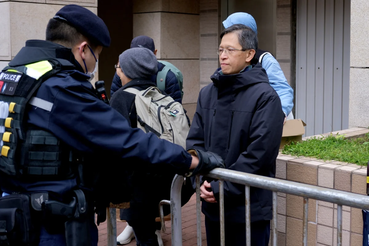 Tang Ngok-kwan (R), a Tiananmen vigil activist and former committee member for Hong Kong Alliance in Support of Patriotic Democratic Movements of China, is queueing for the start of the trial of the now-disbanded Hong Kong Alliance at the West Kowloon Magistrates' Courts on Jan. 22, 2026. (Tommy Wang/AFP via Getty Images)