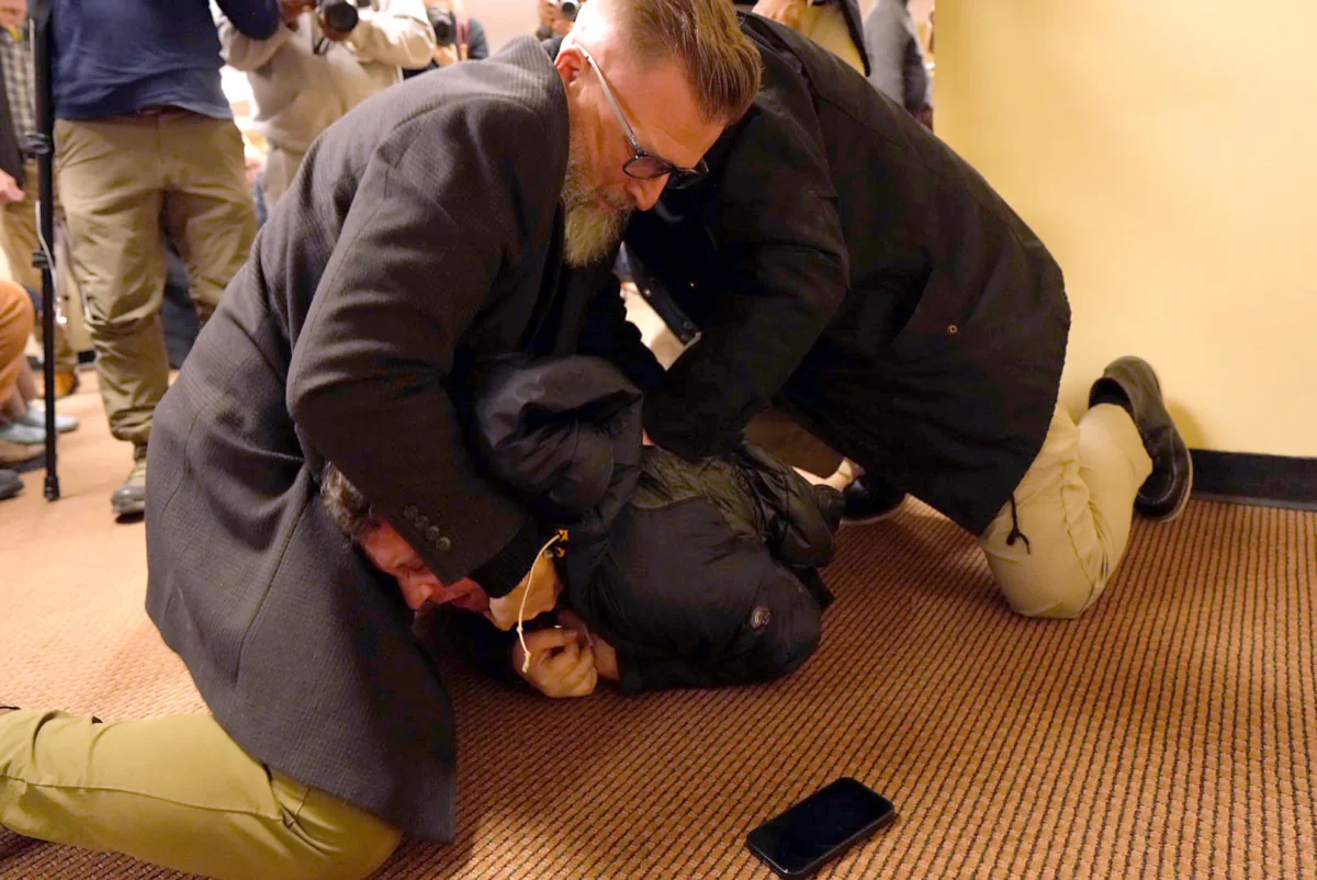 A man is tackled to the ground after spraying an unknown substance on Rep. Ilhan Omar (D-Minn.) during a town hall in Minneapolis on Jan. 27, 2026. (Richard Tsong-Taatarii/Star Tribune via AP)