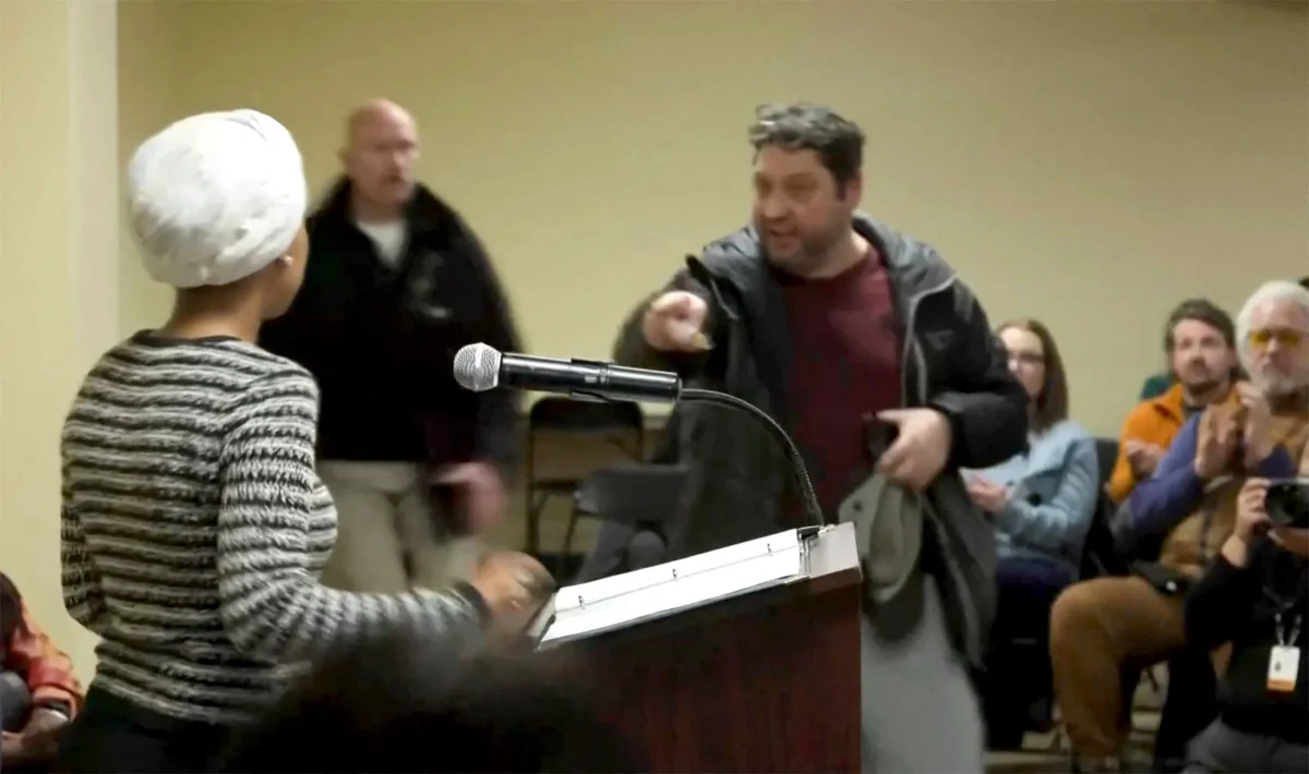 A man shouts at Rep. Ilhan Omar (D-Minn.) after spraying her, during a town hall meeting in Minneapolis on Jan. 27, 2026, in a still image from video. (Maria Alejandra Cardona/Reuters)