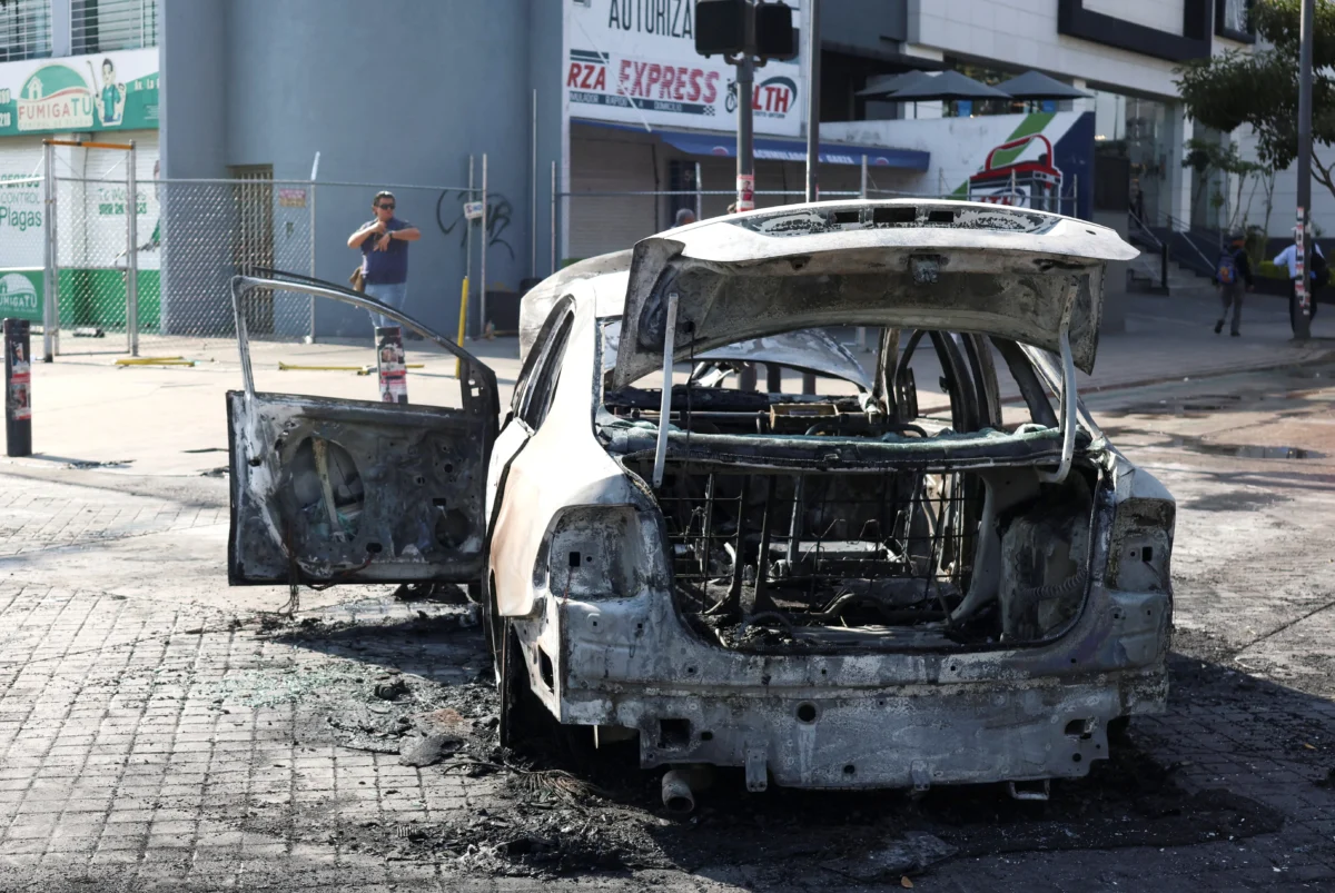 A burned vehicle used as a barricade by organized crime members, following a series of arrests by federal forces, in Guadalajara, Mexico, on Feb. 22, 2026. (Michelle Freyria/Reuters)