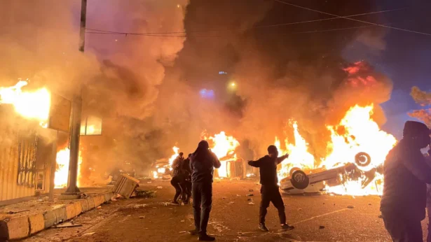 Iranian protesters gather around burning cars while blocking a street during a protest in Tehran, Iran, on Jan. 8, 2026. (Aghasht/Middle East Images/AFP via Getty Images)
