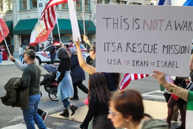 People supporting the joint U.S.-Israeli military strikes against Iran wave banners and signs during a march from World War I Memorial Park toward the White House in Washington, D.C., on Feb. 28, 2026. (Stacy Robinson/The Epoch Times)