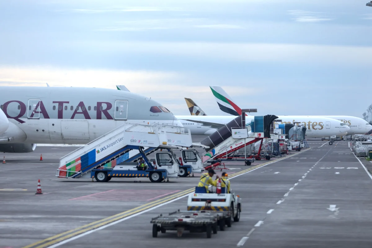 Qatar Airways and Emirates Airways plane is parked at I Gusti Ngurah Rai International Airport as some flights to Dubai and Doha cancelled following strikes on Iran launched by the United States and Israel, in Kuta, Bali, Indonesia, on March 1, 2026. (Johannes Christo/Reuters)