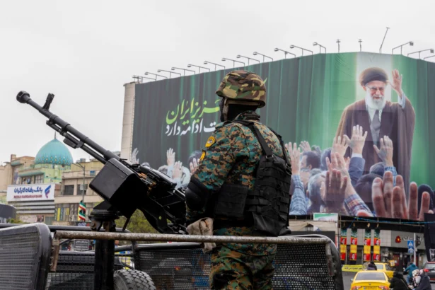 A police officer stands guard beneath a poster of Iran's former leader, Ayatollah Ali Khamenei in Tehran, Iran, on March 10, 2026. (Majid Saeedi/Getty Images)