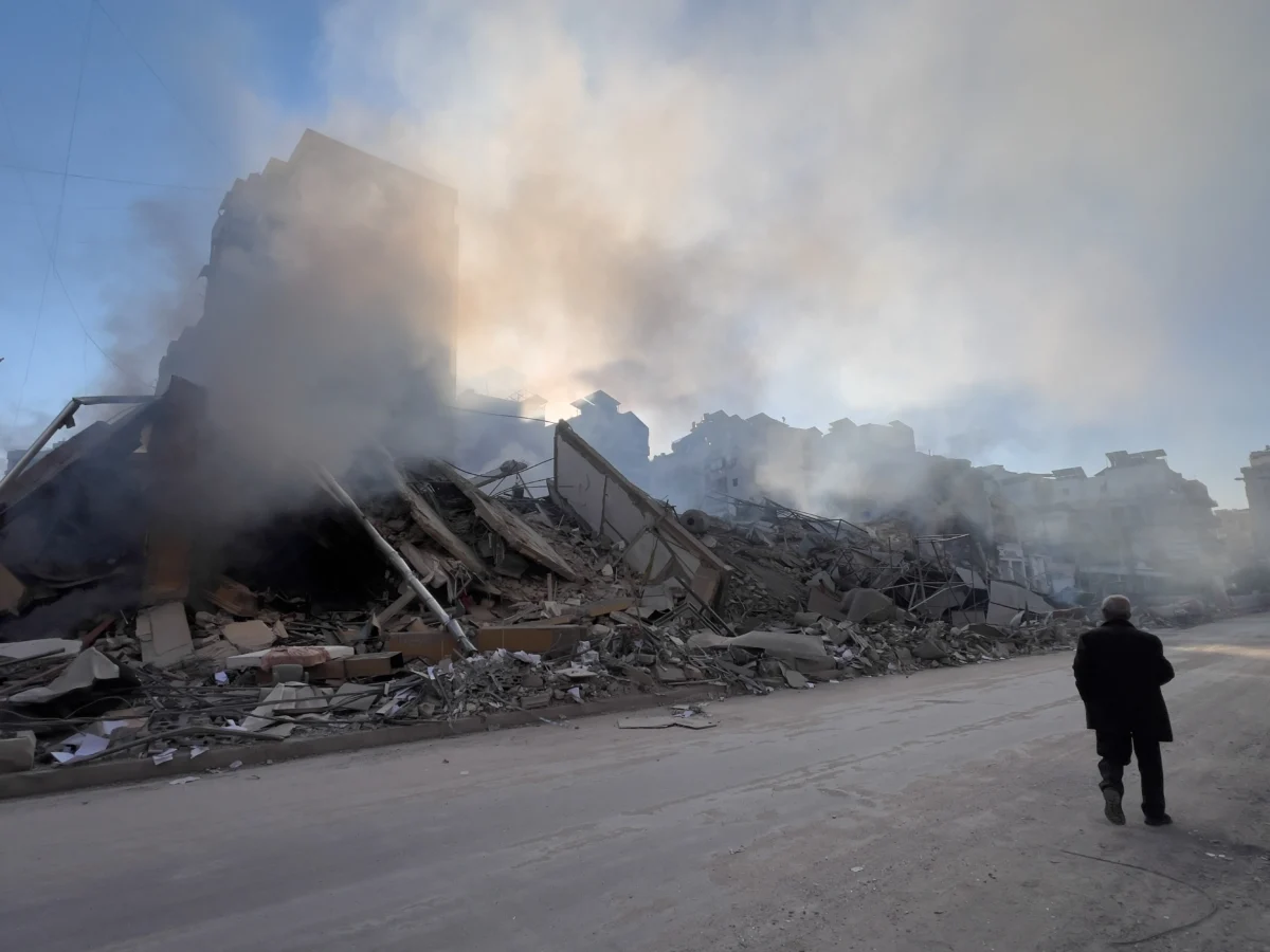 A man passes in front of a destroyed building that housed a branch of Al-Qard Al-Hassan, a non-bank financial institution run by Hezbollah, which was hit by an Israeli airstrike in Dahiyeh, Beirut's southern suburbs, Lebanon, on March 10, 2026. (Hussein Malla/AP Photo)
