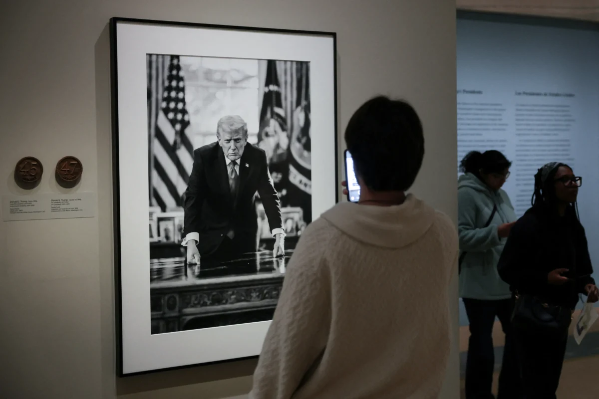 People view the portrait of President Donald Trump, taken by official White House photographer Daniel Torok which is the basis of a proposed U.S. Mint semiquincentennial commemorative coin design, on display at the Smithsonian National Portrait Gallery in Washington on March 19, 2026. (Jonathan Ernst/Reuters)