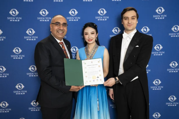 Conservative MP Amarjeet Gill presents Shen Yun hosts with a proclamation honouring Shen Yun at the Four Seasons Centre for the Performing Arts in Toronto on March 28, 2026. (The Epoch Times)