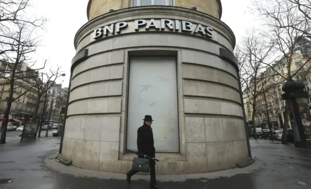 In this Feb. 5, 2013, file photo, a man walks past the French bank BNP Paribas headquarters in Paris. (Jacques Brinon/AP Photo)