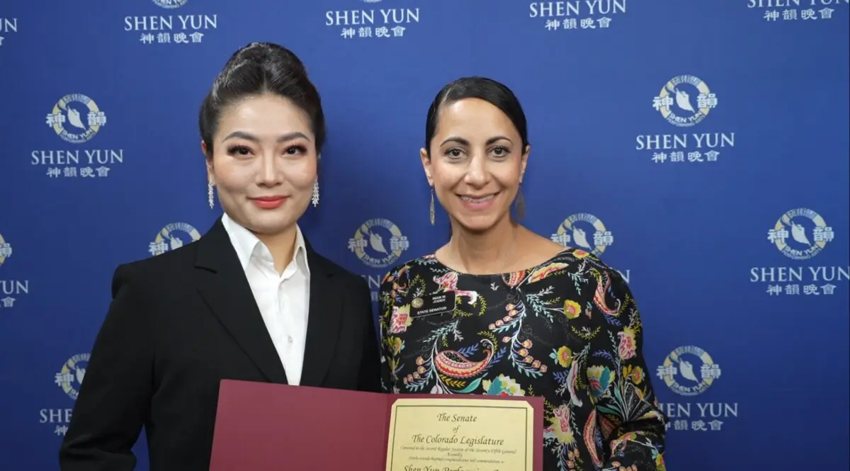 Shen Yun's soprano (L) accepts a tribute presented to Shen Yun Performing Arts by Senator Iman Jodeh (R) at The Buell Theatre, on April 12, 2026. (NTD)