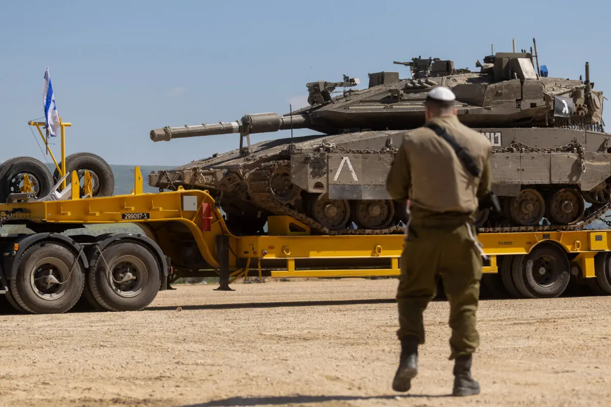 An Israeli soldier stands near a truck carrying an Israeli tank in northern Israel near the border with Lebanon on March 5, 2026. (Amir Levy/Getty Images)