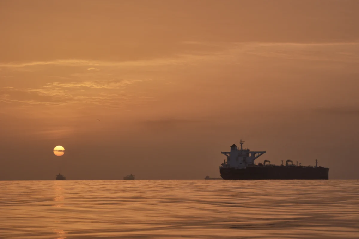 The sun rises behind tankers anchored in the Strait of Hormuz off the coast of Qeshm Island, Iran, on April 18, 2026. (Asghar Besharati/AP Photo)