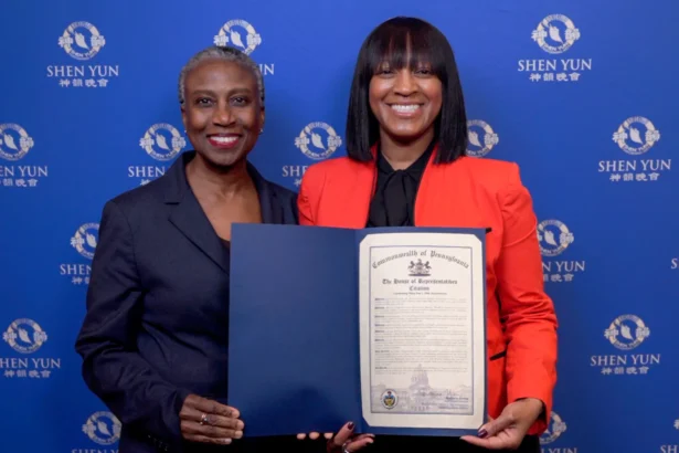 District Office Director Belinda Mills (R) presents a Citation to Shen Yun Performing Arts on behalf of Rep. Regina Young at the Miller Theater on April 18, 2026. (NTD)