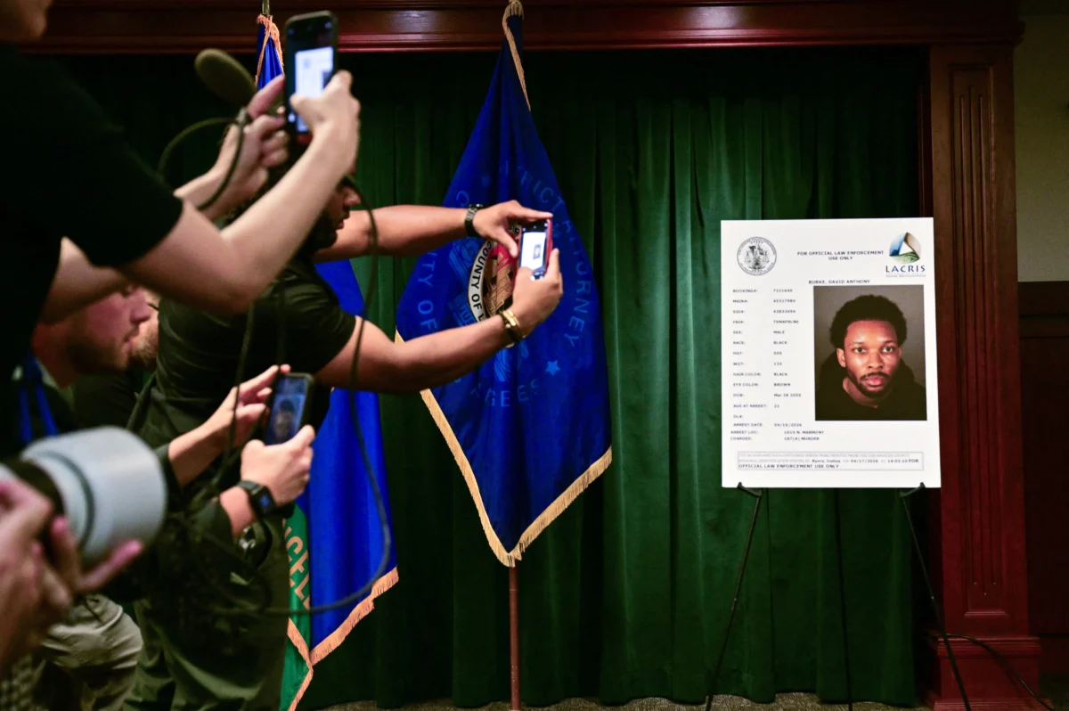 Journalists take pictures of a booking photo of David Anthony Burke, known as D4vd, before the start of a press briefing on the case against D4vd in at the Hall of Justice in Los Angeles on April 20, 2026. (Frederic J. Brown/AFP via Getty Images)
