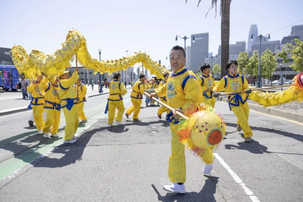Yu Yang, a Bay Area customized tour guide, leads the dragon dance in the parade on May 9 in San Francisco. (Lear Zhou/The Epoch Times)