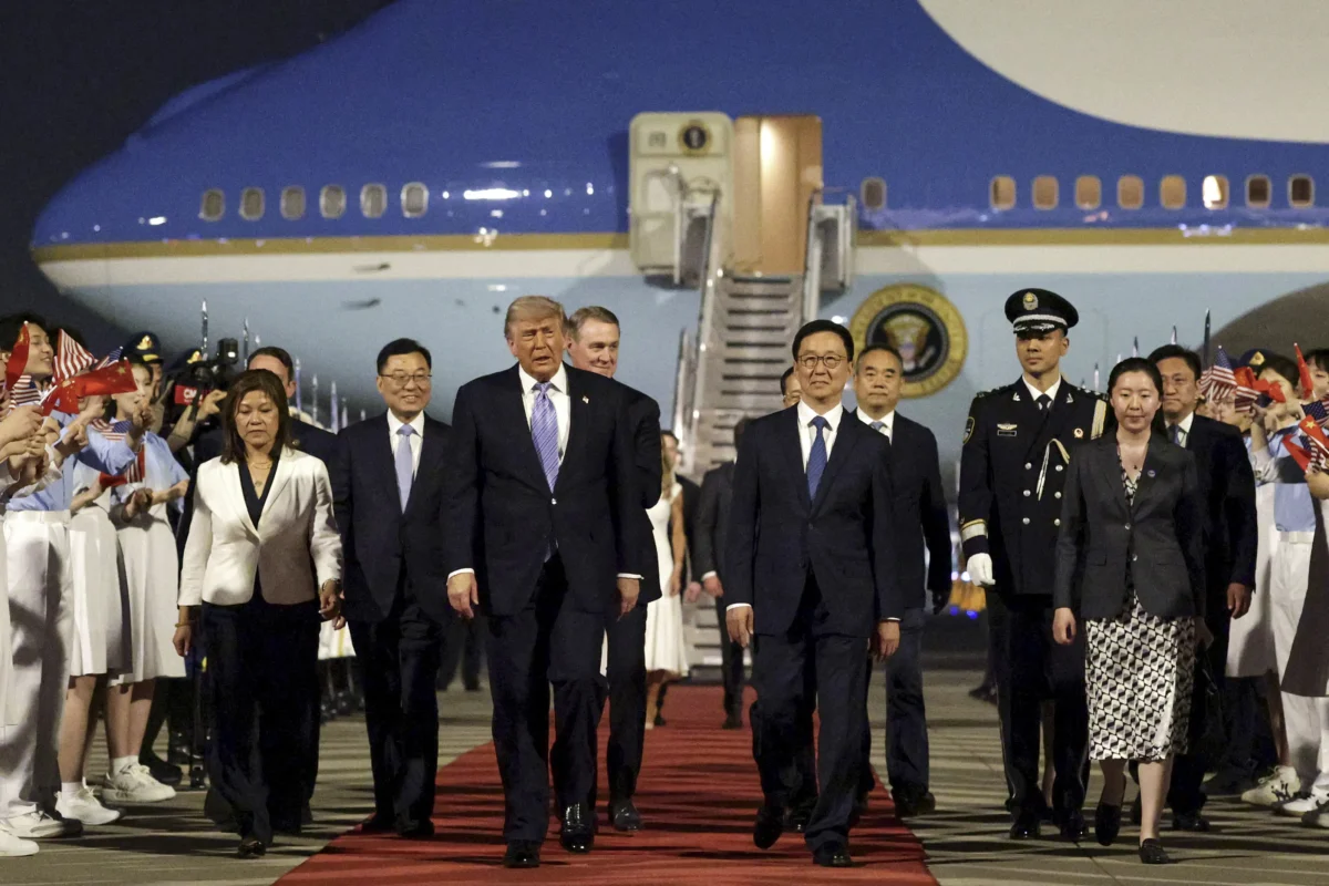 President Donald Trump (C) is joined by Chinese officials as he arrives at Beijing Capital International Airport in China on May 13, 2026. (Alex Wong/Getty Images)