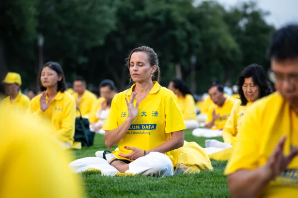 Falun Dafa practitioners practice exercises before taking part in a candlelight vigil commemorating Falun Gong practitioners who were persecuted to death by the Chinese Communist Party in China, in Washington on July 17, 2025. (Madalina Kilroy/The Epoch Times)