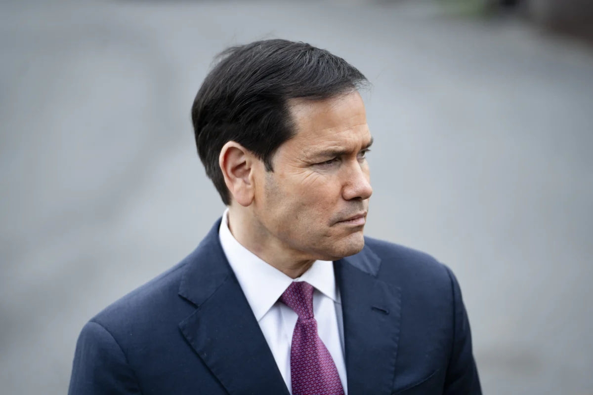 Secretary of State Marco Rubio listens as President Donald Trump speaks to members of the press before departing the White House on March 20, 2026. (Madalina Kilroy/The Epoch Times)