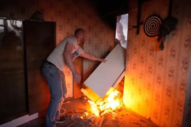 A local resident moves a refrigerator on fire after a Russian missile attack in Kyiv, Ukraine, on May 24, 2026. (AP Photo/Efrem Lukatsky)