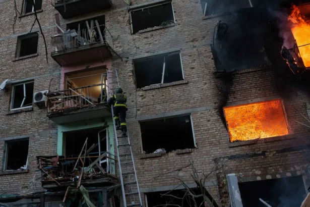 A rescue worker climbs on a ladder to help evacuate people from a residential building being destroyed after a Russian strike on Kyiv, Ukraine, Sunday, May 24, 2026. (AP Photo/Evgeniy Maloletka)